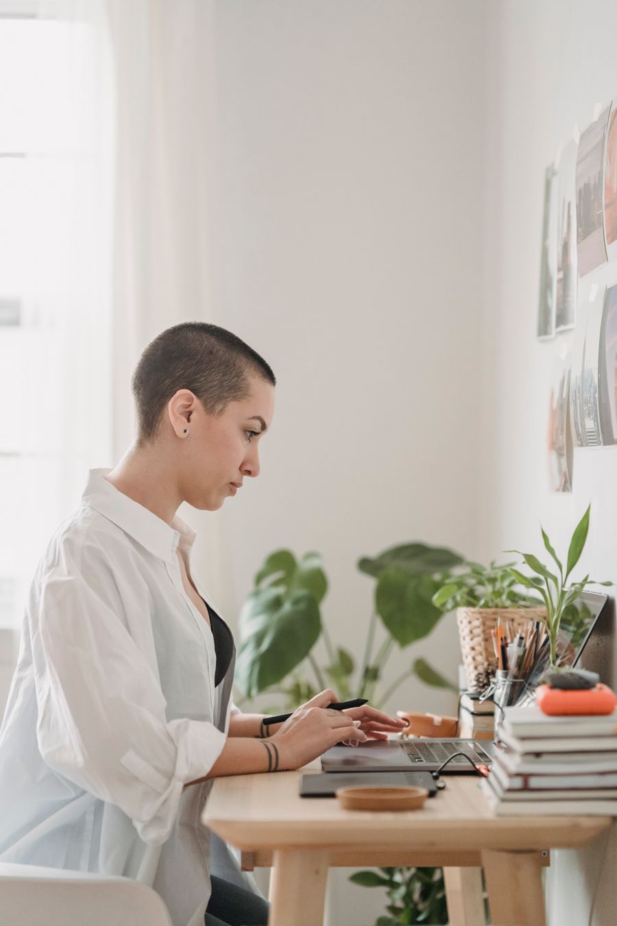 Side view of a person sitting at a desk and using a laptop