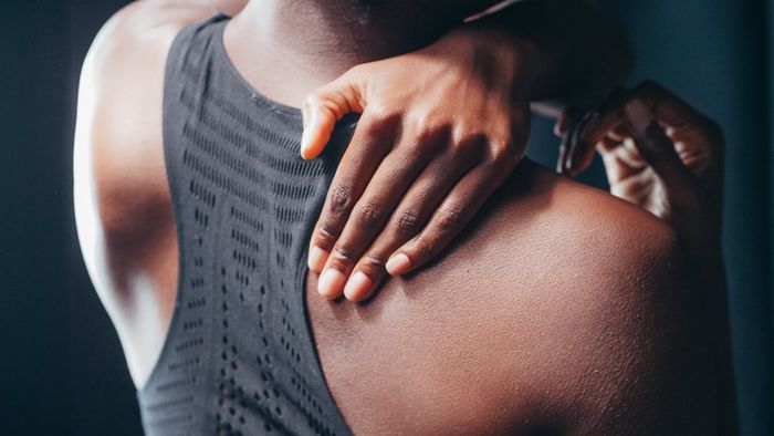 Close-up from behind of a hand resting on a shoulder