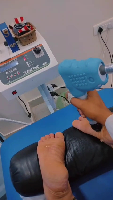 Close-up of physiotherapy equipment being used near a person's foot